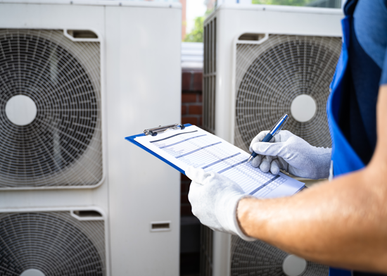 Technician inspecting air conditioning units